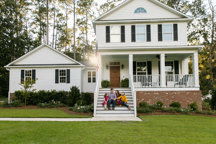 family on front steps of new home