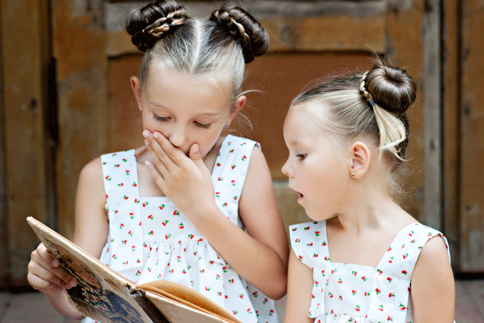 young girls reading outside